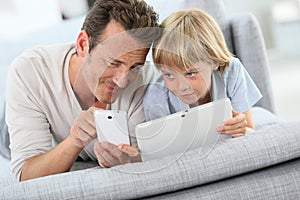 Portrait of father and son playing with electronical devices