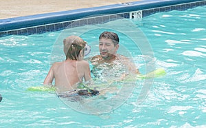 Portrait of father and son playing in a pool
