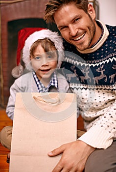 Portrait, father and son with smile for Christmas gift in house, hat and boy with happiness for holiday. Man, relax and