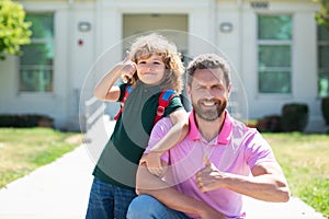 Portrait of father and son with thumbs up near school park. Back to school.