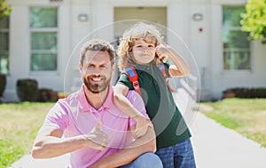 Portrait of father and son with thumbs up near school park. Back to school.