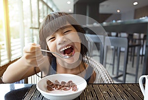 Portrait of feeling happy a young girl having breakfast on table
