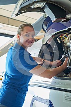 Portrait Of Female Aero Engineer Working On Helicopter In Hangar