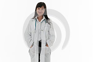 Portrait of female asian doctor stands with hands in pocket looking at camera smiling. Young woman with long hair in white gown. C