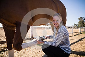 Portrait of female attaching horse shoe