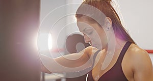 Portrait of female boxer with her arm on the punching bag