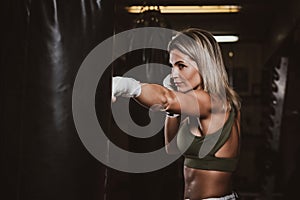 Portrait of female boxer on her training with punching bag