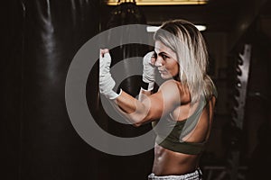 Portrait of female boxer on her training with punching bag