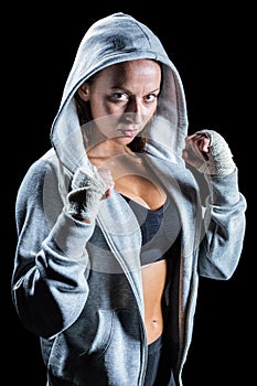 Portrait of female boxer in hood with fighting stance