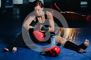 portrait of a female boxer in red gloves in the gym after training