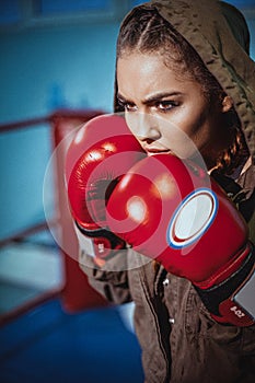 Portrait of female boxer in sport wear with fighting stance against spotlight. fitness blonde girl in sport wear