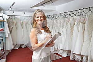 Portrait Of Female Bridal Store Owner With Wedding Dresses