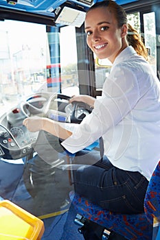 Portrait Of Female Bus Driver Behind Wheel