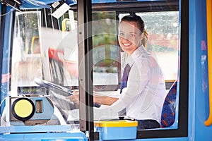 Portrait Of Female Bus Driver Behind Wheel