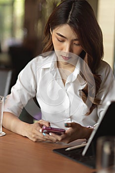 Portrait of female business worker socialise with her friends on smartphone