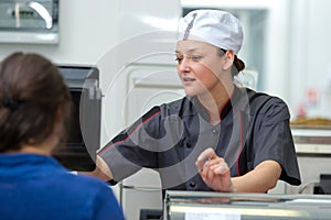 portrait female butcher serving customer