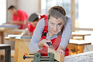 portrait female carpenter chiselling wood