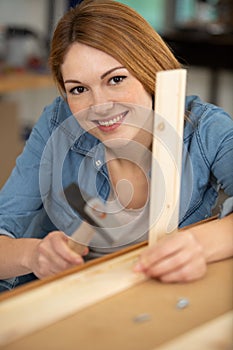 portrait female carpenter standing with work tool