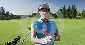 Portrait of female caucasian golf player crossing her arms while standing at golf course