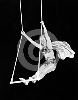 Portrait of a female circus performer performing on a trapeze bar photo