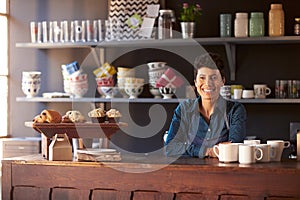 Portrait Of Female Coffee Shop Owner Standing Behind Counter