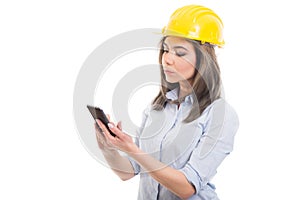 Portrait of female constructor browsing on smartphone photo