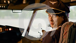 Portrait of female copilot in aviation uniform flying airplane