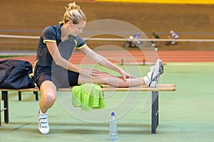 Portrait female cyclist stretching leg