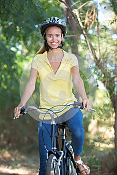 Portrait female cyclist wearing helmet in countryside