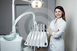 Portrait of female dentist .She standing in her dentist office. Female dentist wearing a white robe