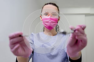 Portrait of female dentist. She standing at her office in mask