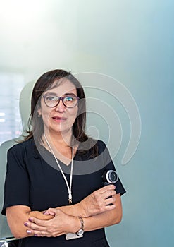 Portrait of a female dermatologist doctor with a dermatology magnifying glass on a gray glass background