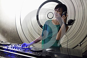 A portrait of a female DJ playing music in a nightclub