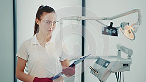 Portrait of a female doctor and future dentist. Caucasian woman with a folder of documents in her hands in the dentist s