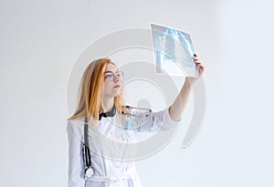 Portrait of a female doctor looking at a chest X-ray.