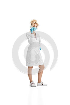 Portrait of female doctor, nurse or cosmetologist in white uniform and blue gloves over white background