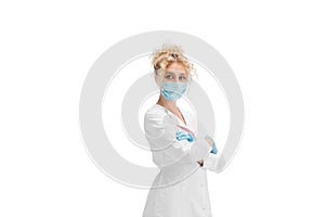 Portrait of female doctor, nurse or cosmetologist in white uniform and blue gloves over white background