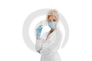 Portrait of female doctor, nurse or cosmetologist in white uniform and blue gloves over white background