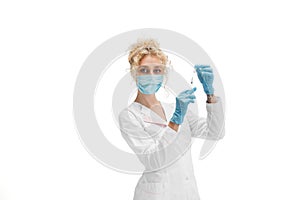 Portrait of female doctor, nurse or cosmetologist in white uniform and blue gloves over white background