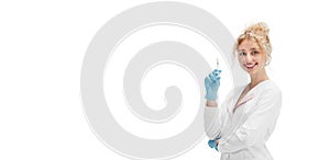 Portrait of female doctor, nurse or cosmetologist in white uniform and blue gloves over white background