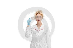 Portrait of female doctor, nurse or cosmetologist in white uniform and blue gloves over white background