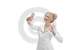 Portrait of female doctor, nurse or cosmetologist in white uniform and blue gloves over white background