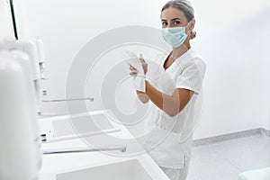 Portrait of female doctor or nurse drying hands with paper tissue at hospital after Washing Hands.