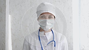 Portrait of female doctor or nurse in uniform and mask looking straight at camera. Hard work, medical, epidemic concept