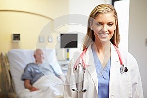 Portrait Of Female Doctor With Patient In Background