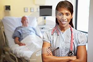 Portrait Of Female Doctor With Patient In Background