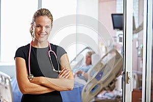 Portrait Of Female Doctor With Patient In Background