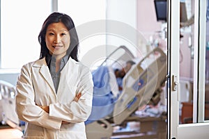 Portrait Of Female Doctor With Patient In Background