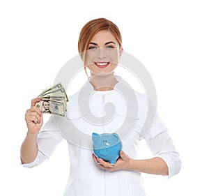 Portrait of female doctor with piggy bank