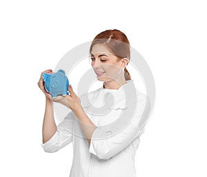 Portrait of female doctor putting coin into piggy bank